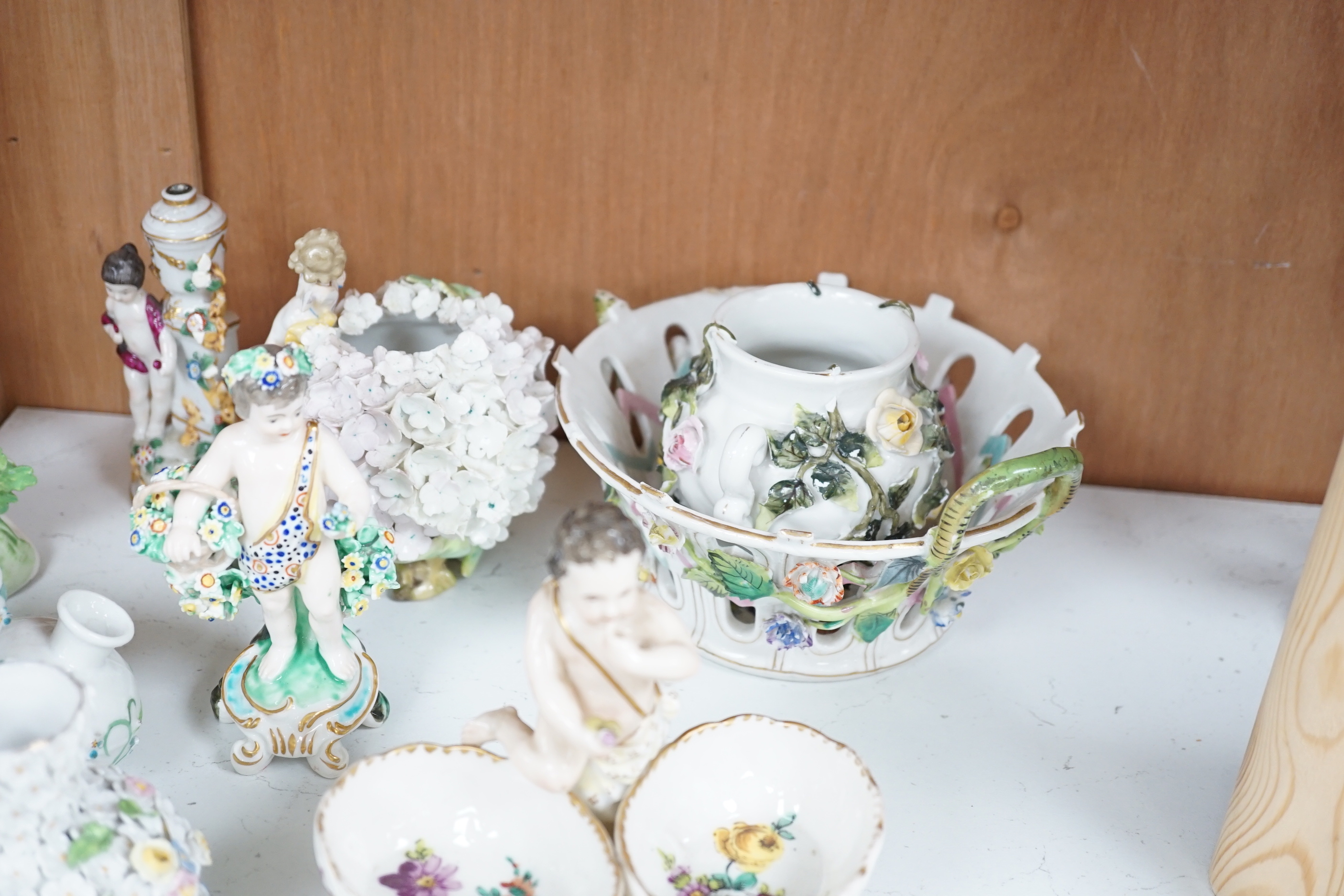 A group of German flower encrusted tableware, including a matched Meissen cup and saucer, lidded box, salts, figures, etc., tallest figure 12cm